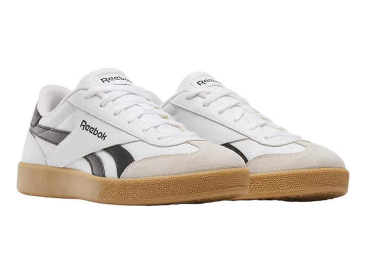 Tenis Reebok blancos con detalles en negro y suela de goma color café.