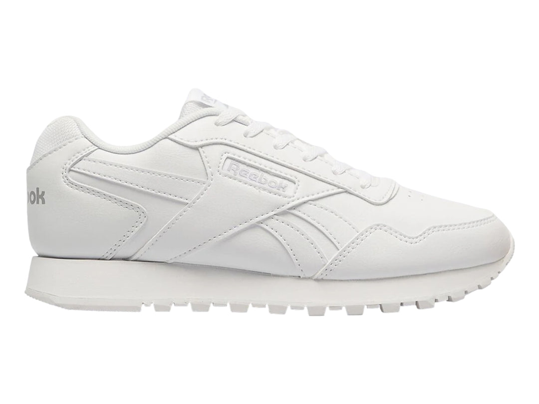 Tenis deportivos Reebok de color blanco para niños con suela blanca y cordones.
