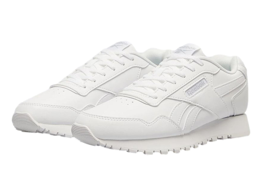 Tenis deportivos Reebok de color blanco para niños con suela blanca y cordones.