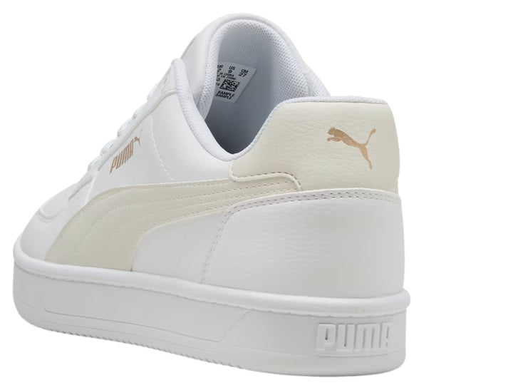 Tenis PUMA blancos con detalles en dorado, diseño clásico de corte bajo y suela blanca.