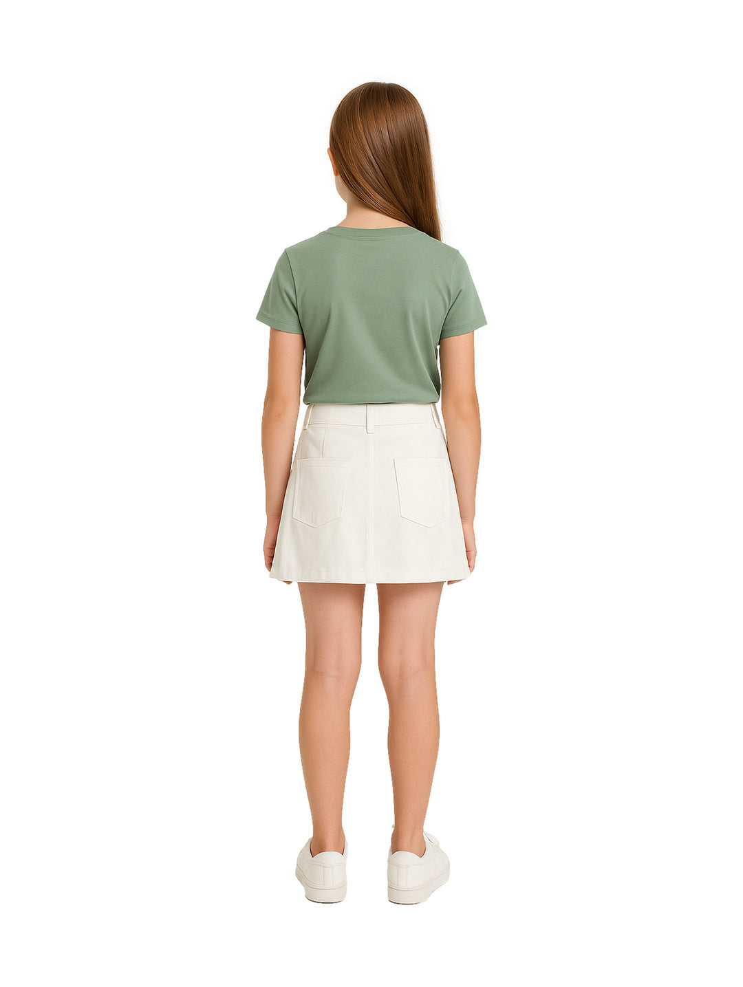 Niña vistiendo una falda blanca corta con bolsillos frontales y camiseta verde.