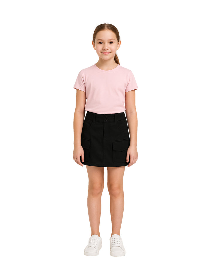 Niña modelando una falda corta color negro con bolsillos laterales y playera rosa.