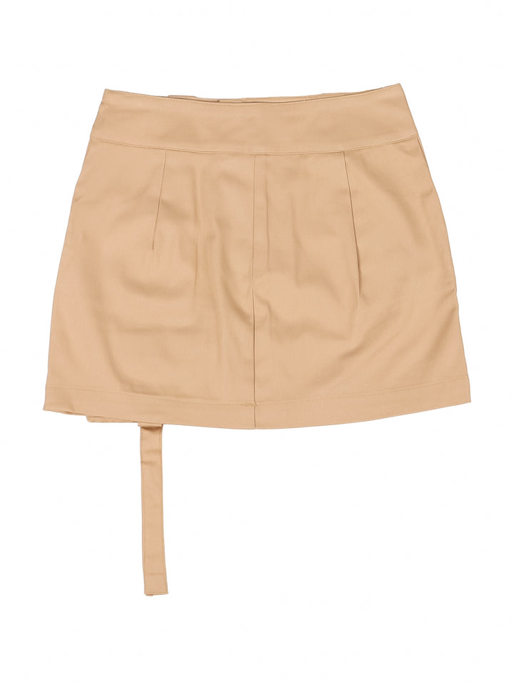 Niña vistiendo una falda corta color khaki con un bolsillo lateral tipo cargo y botones en la cintura.