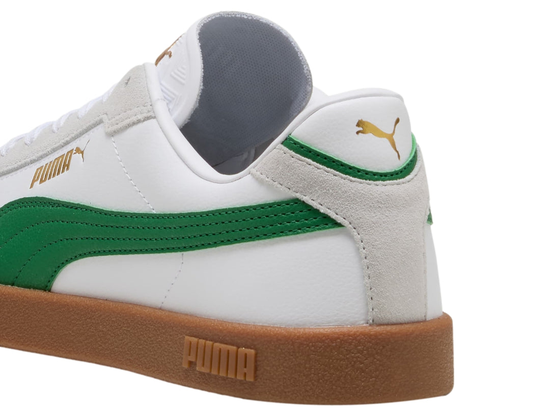Tenis PUMA blancos con franja verde y suela de goma color café.