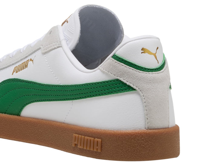 Tenis PUMA blancos con franja verde y suela de goma color café.