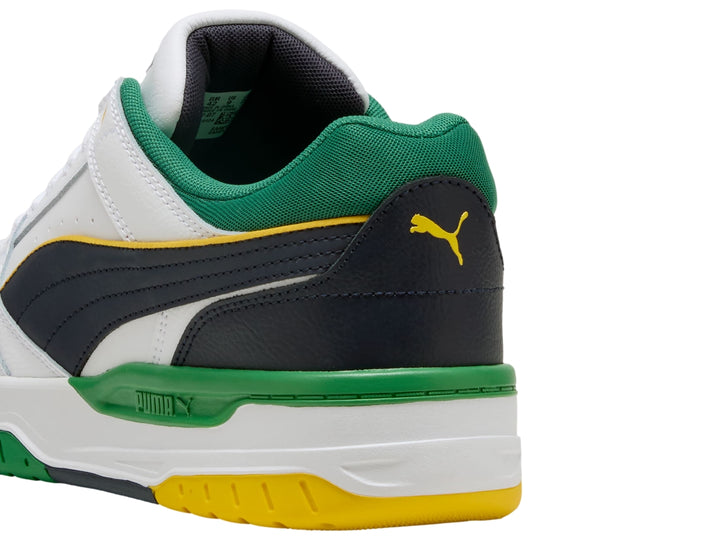 Tenis PUMA Rebound Retro blancos con acentos en verde, azul marino y amarillo.