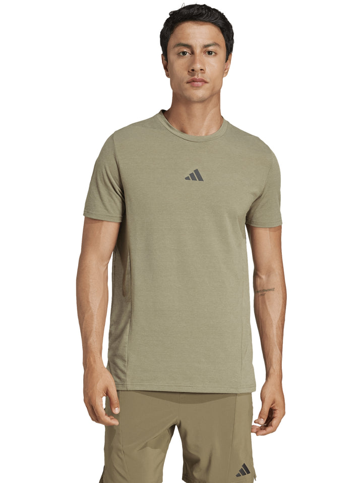 Hombre vistiendo camiseta deportiva de manga corta color verde oliva con logo de Adidas en el pecho.
