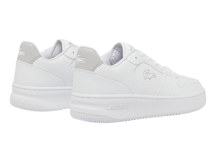 Tenis Lacoste blancos de corte bajo con detalle gris en el talón y suela blanca.