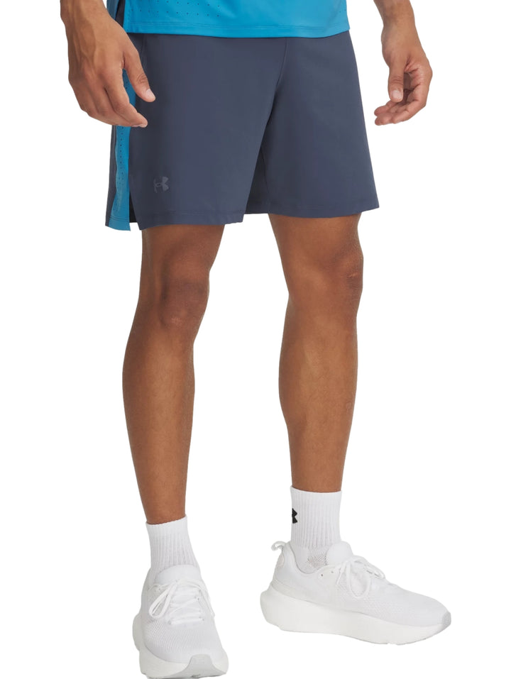 Shorts deportivos Under Armour color gris con franja lateral azul, usados con tenis blancos.