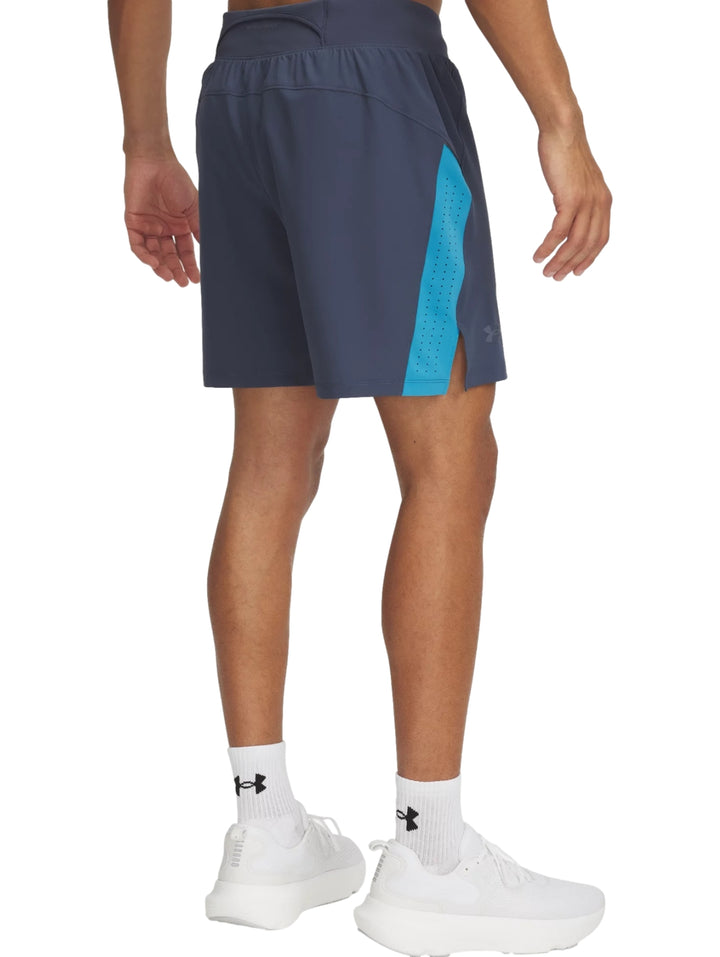 Shorts deportivos Under Armour color gris con franja lateral azul, usados con tenis blancos.