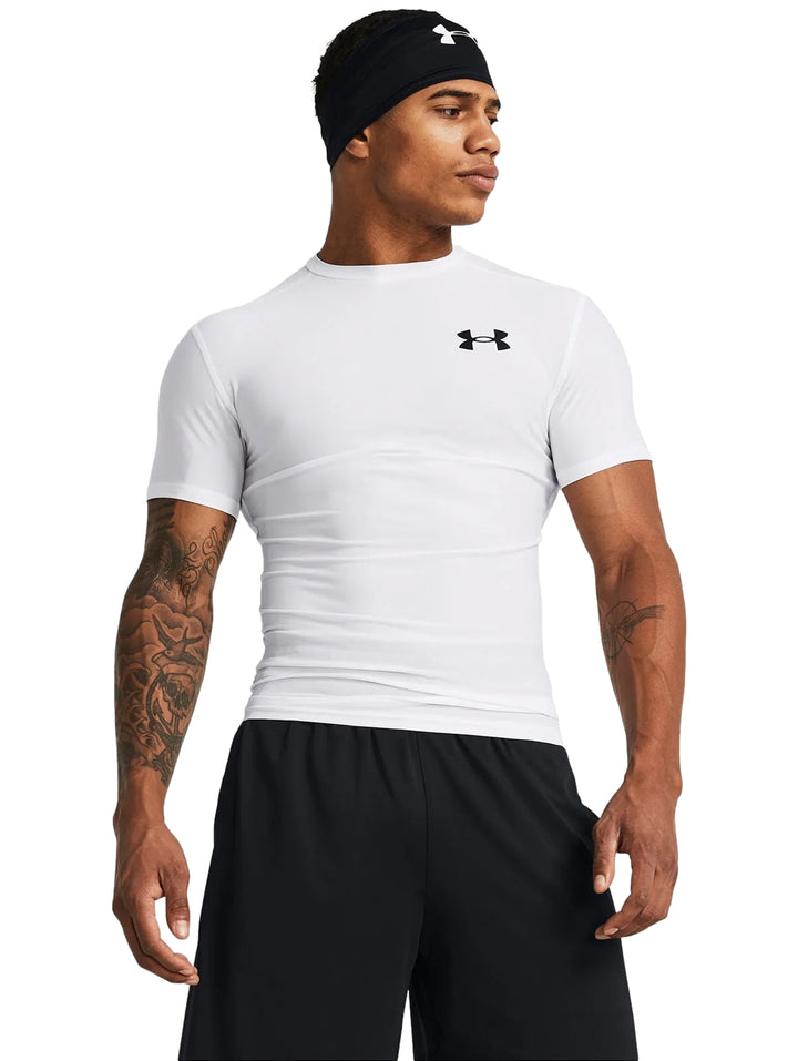 Hombre vistiendo camiseta de compresión blanca de manga corta marca Under Armour.