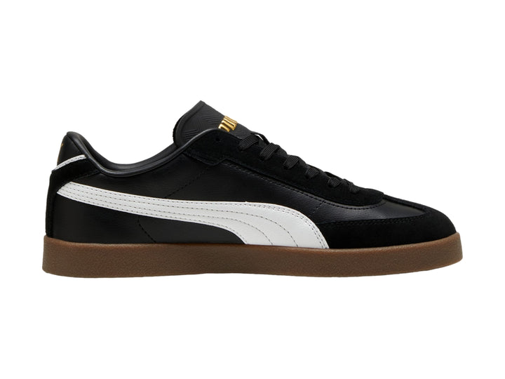 Tenis PUMA color negro con franja blanca lateral y suela de goma color café.