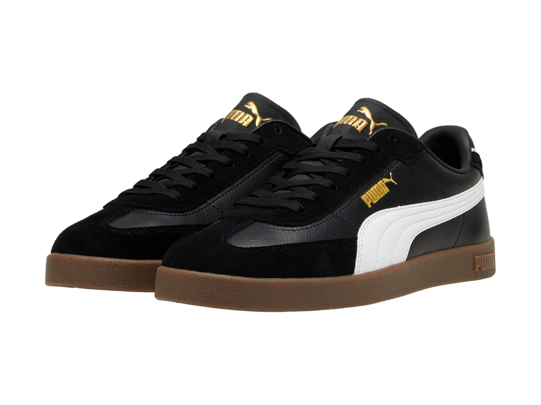 Tenis PUMA color negro con franja blanca lateral y suela de goma color café.