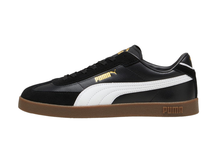 Tenis PUMA color negro con franja blanca lateral y suela de goma color café.