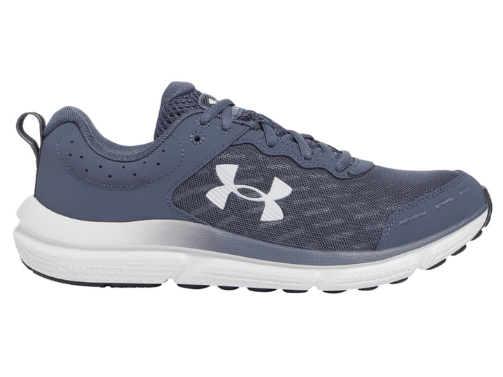 Tenis deportivos Under Armour color gris con suela blanca y logotipo blanco en el costado.
