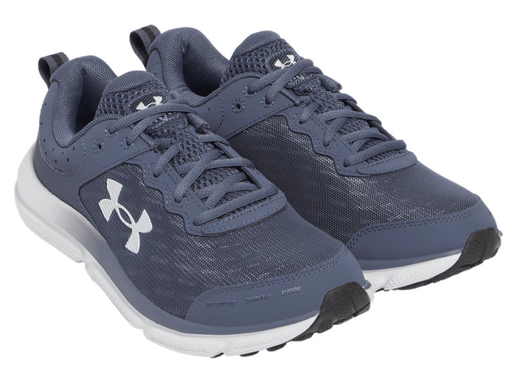 Tenis deportivos Under Armour color gris con suela blanca y logotipo blanco en el costado.