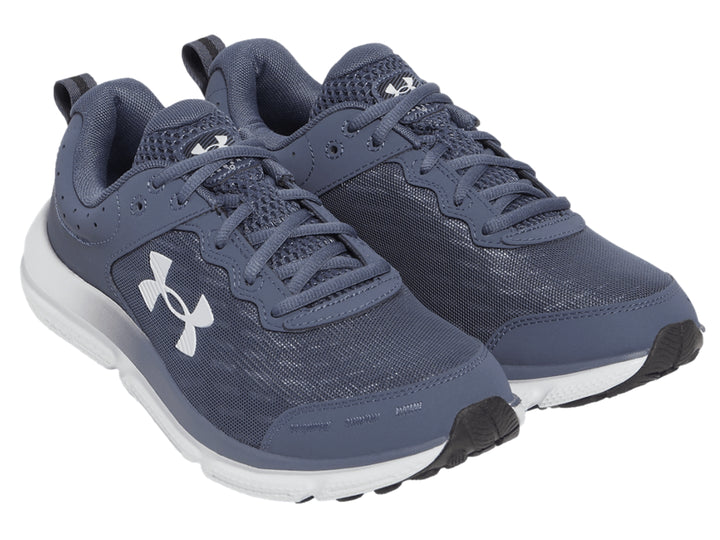 Tenis deportivos Under Armour color gris con suela blanca y logotipo blanco en el costado.
