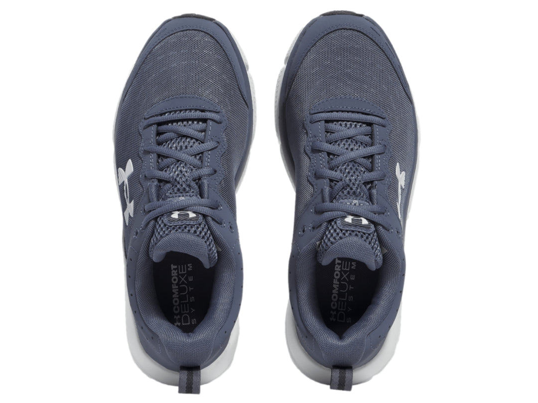 Tenis deportivos Under Armour color gris con suela blanca y logotipo blanco en el costado.