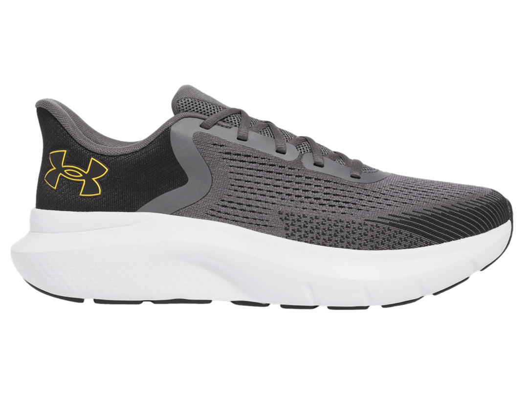 Tenis deportivos Under Armour color gris con suela blanca y logo dorado.