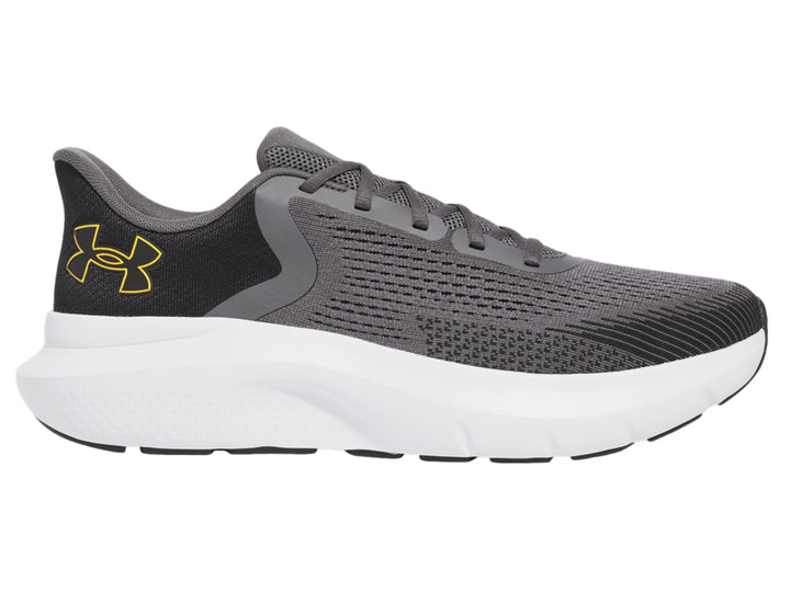 Tenis deportivos Under Armour color gris con suela blanca y logo dorado.