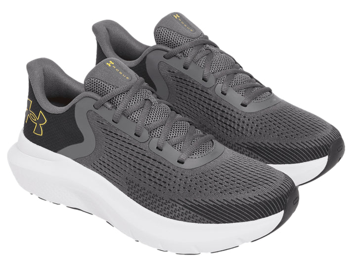 Tenis deportivos Under Armour color gris con suela blanca y logo dorado.