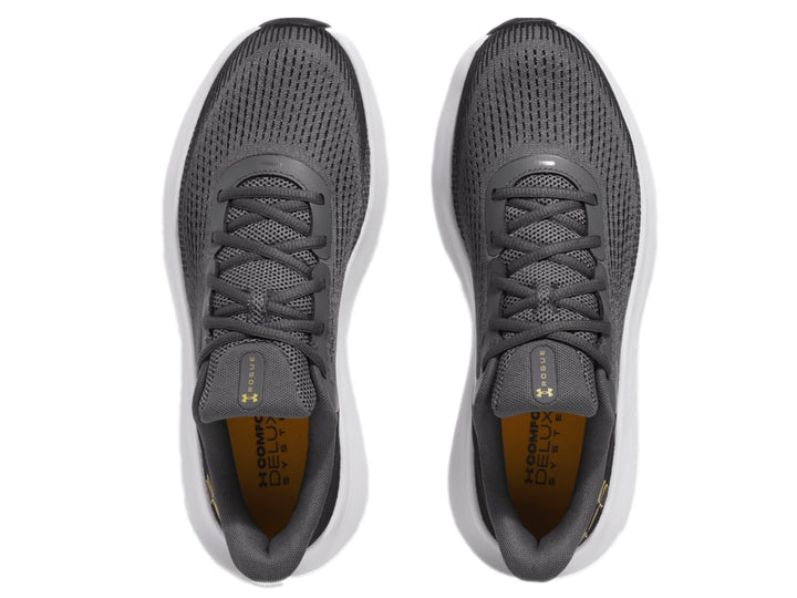 Tenis deportivos Under Armour color gris con suela blanca y logo dorado.