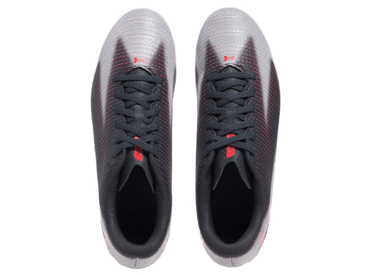 Zapato de fútbol Under Armour color gris con patrón de rayas rojas y suela blanca.