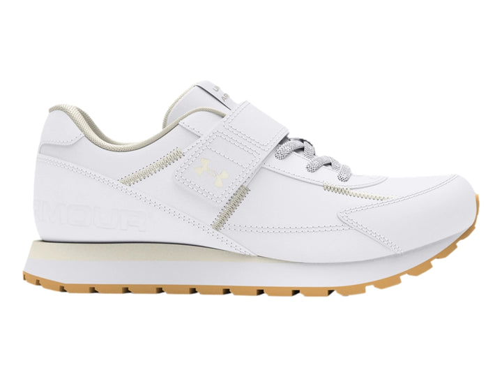 Tenis deportivos Under Armour blancos para niño con cierre de velcro y suela color beige.