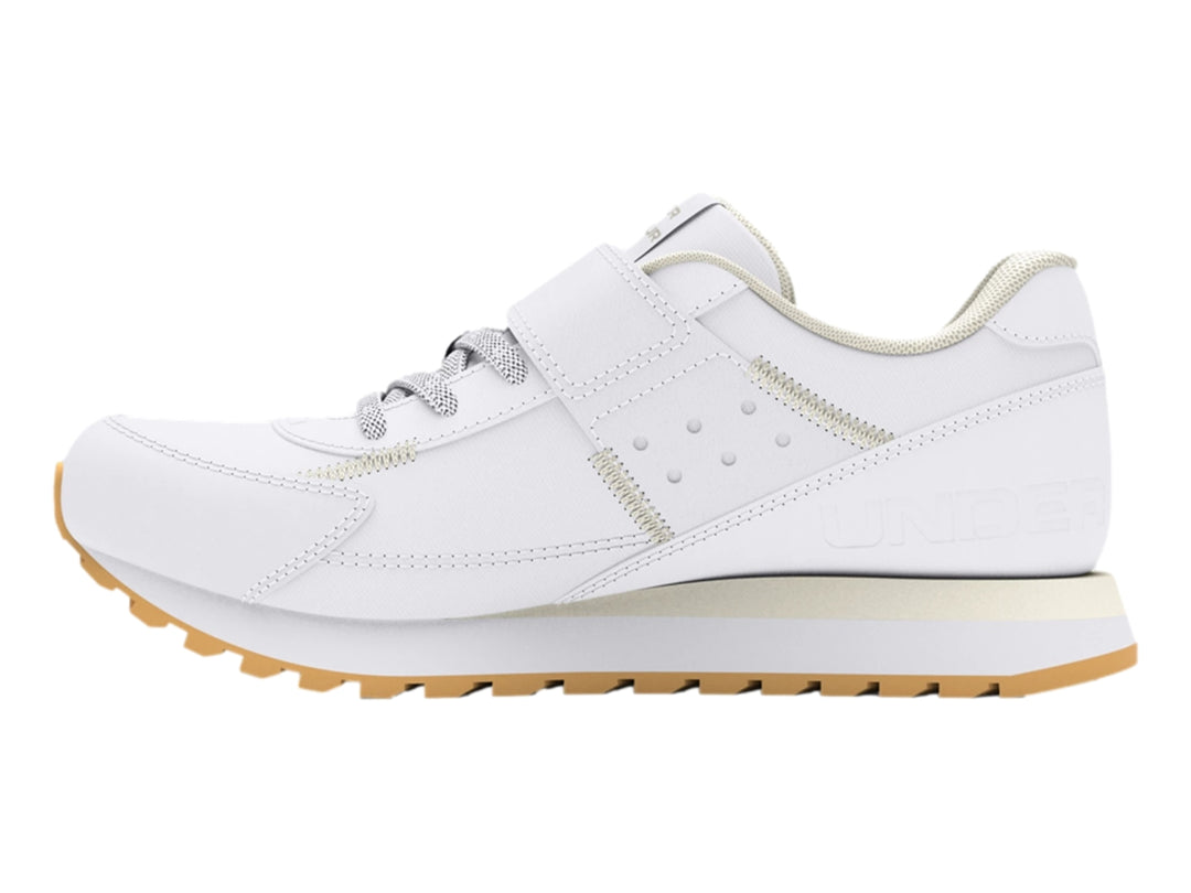 Tenis deportivos Under Armour blancos para niño con cierre de velcro y suela color beige.