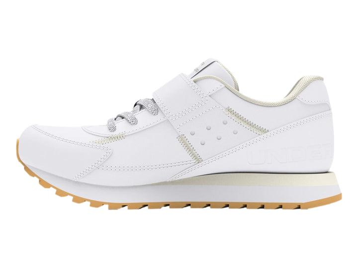 Tenis deportivos Under Armour blancos para niño con cierre de velcro y suela color beige.