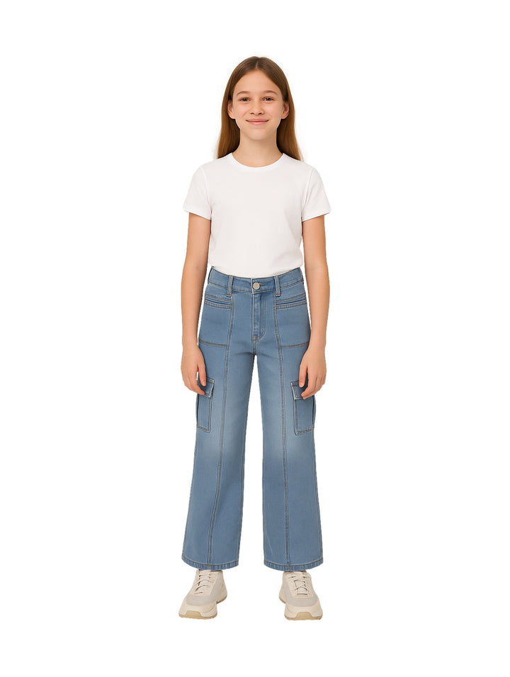 Niña vistiendo pantalones cargo de mezclilla azul claro con pierna ancha y camiseta blanca.