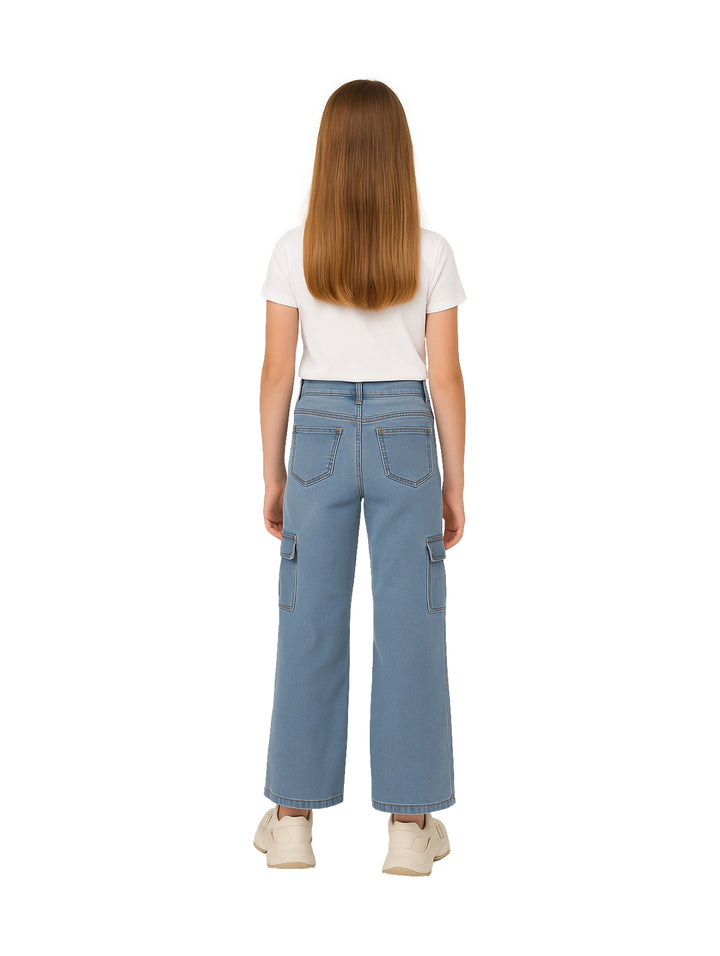 Niña vistiendo pantalones cargo de mezclilla azul claro con pierna ancha y camiseta blanca.