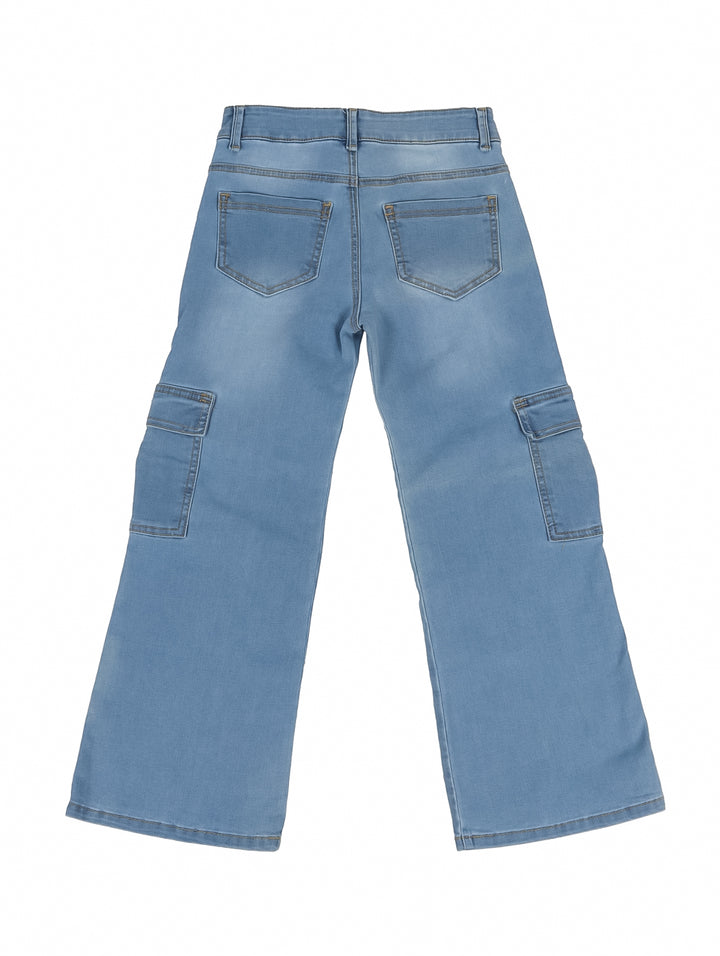 Niña vistiendo pantalones cargo de mezclilla azul claro con pierna ancha y camiseta blanca.