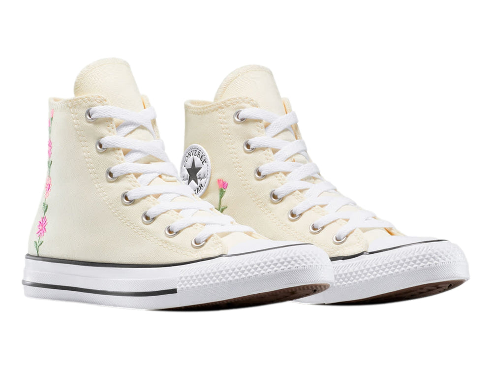Tenis Converse Chuck Taylor All Star color beige con detalles de flores bordadas en rosa y verde.