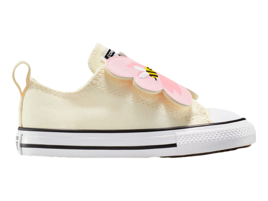 Tenis Converse beige para niño o niña con correa ajustable decorada con una flor rosa y una pequeña abeja.