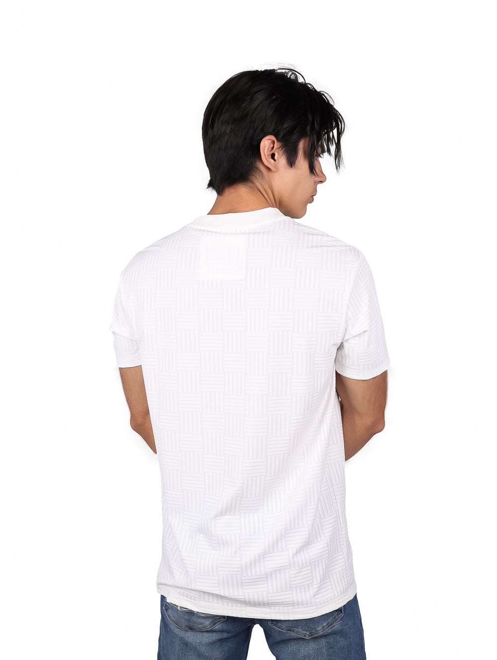 Hombre vistiendo playera blanca de manga corta con patrón geométrico sutil y cuello redondo.