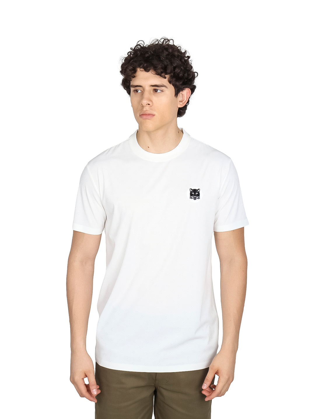 Hombre vistiendo una playera blanca de manga corta con un pequeño logo negro en el pecho.
