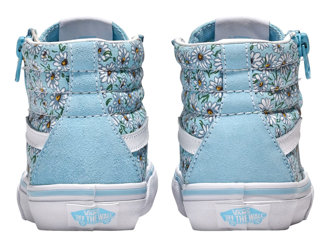 Tenis Vans azul con estampado de margaritas blancas, cierre lateral y suela blanca.