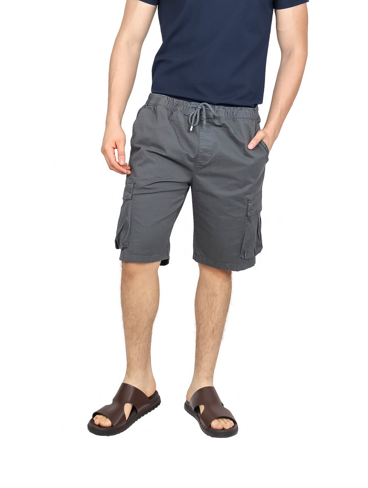 Hombre vistiendo bermudas cargo color gris Oxford con cintura elástica y bolsillos laterales.