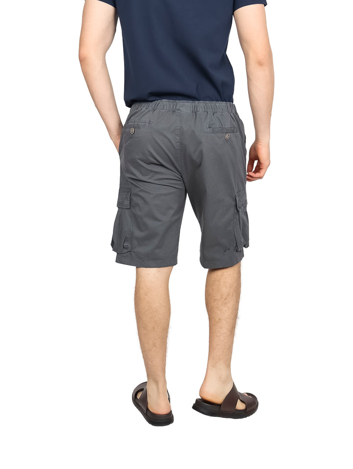 Hombre vistiendo bermudas cargo color gris Oxford con cintura elástica y bolsillos laterales.