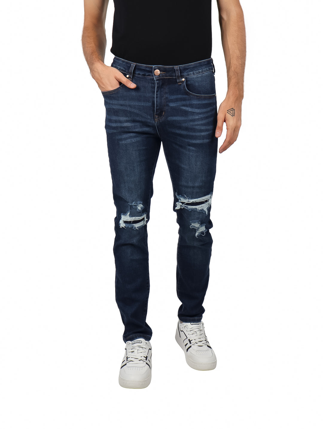 Hombre vistiendo jeans slim fit color azul oscuro con detalles rotos en las rodillas.