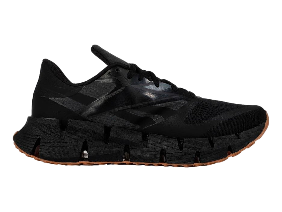 Tenis deportivos Reebok color negro con suela segmentada y base de goma marrón.