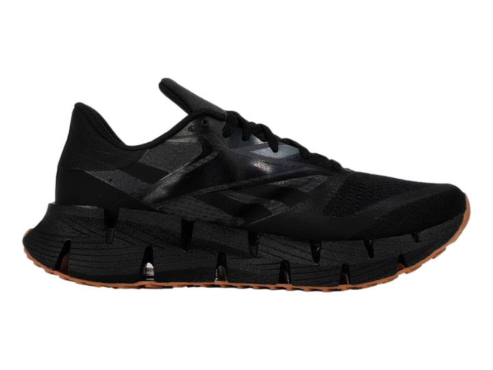 Tenis deportivos Reebok color negro con suela segmentada y base de goma marrón.