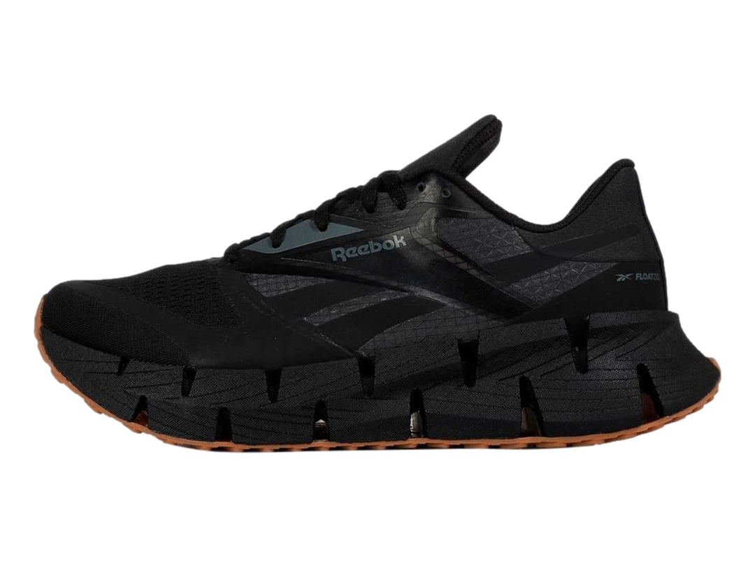 Tenis deportivos Reebok color negro con suela segmentada y base de goma marrón.