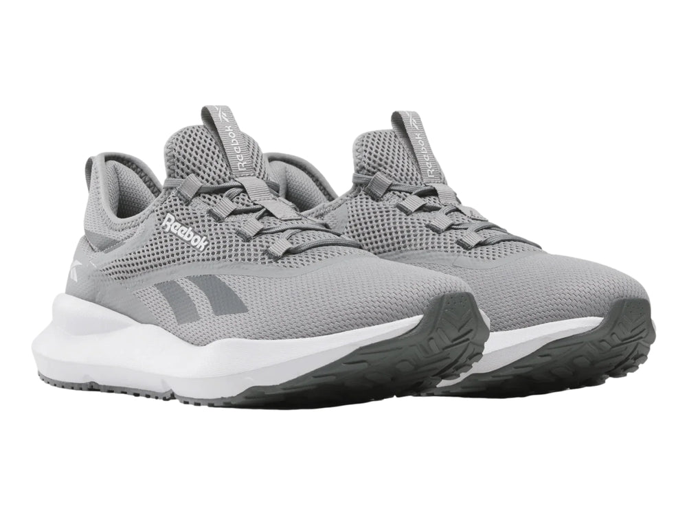 Tenis deportivos Reebok color gris con suela blanca y tejido de malla.