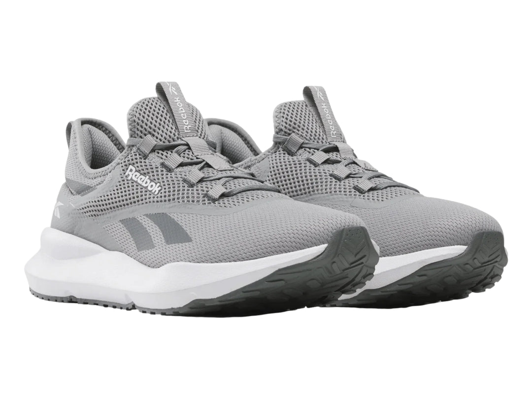 Tenis deportivos Reebok color gris con suela blanca y tejido de malla.