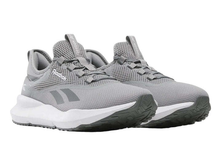Tenis deportivos Reebok color gris con suela blanca y tejido de malla.