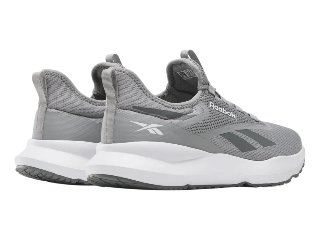 Tenis deportivos Reebok color gris con suela blanca y tejido de malla.