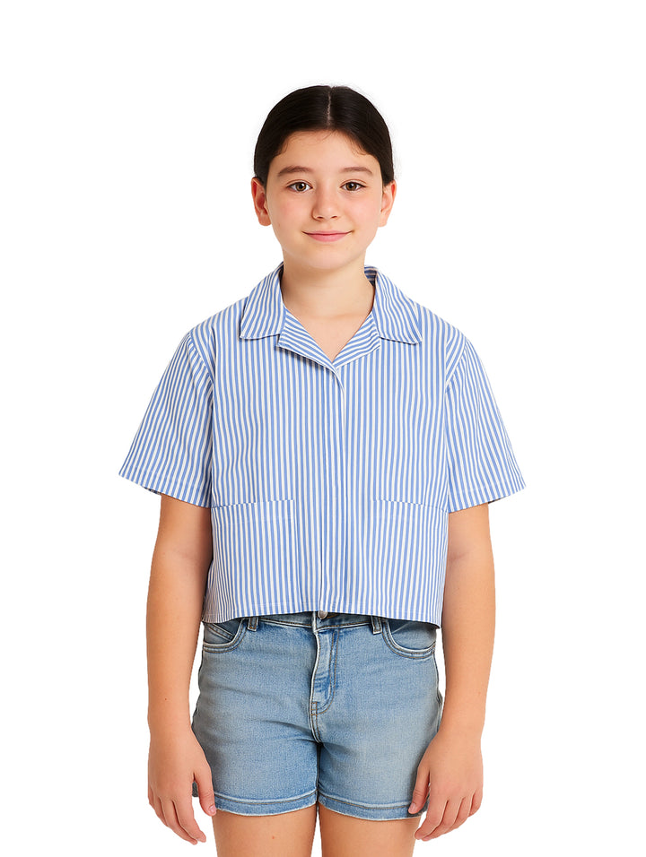 Niña vistiendo una camisa de rayas azules y blancas de manga corta y pantalones cortos de mezclilla.