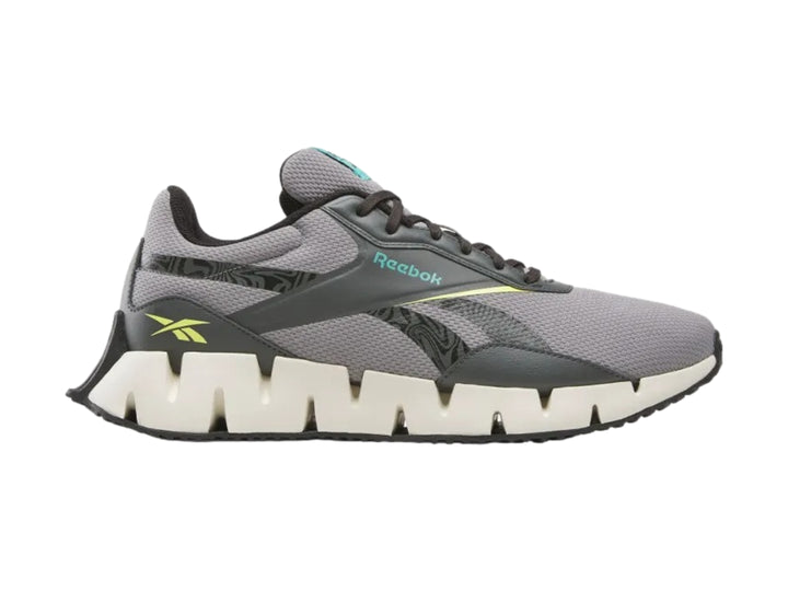 Tenis deportivos Reebok en color gris con suela blanca en forma de zig-zag.